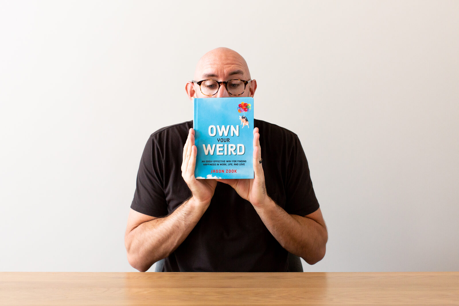 Jason Zook holding Own Your Weird, 2019